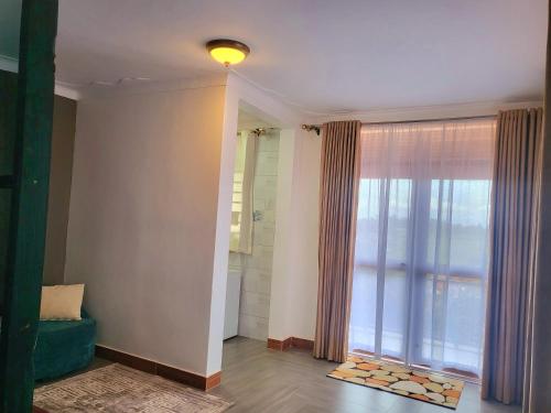 a bathroom with a large window and a green couch at Kampala Studio with Lake Breeze in Kampala