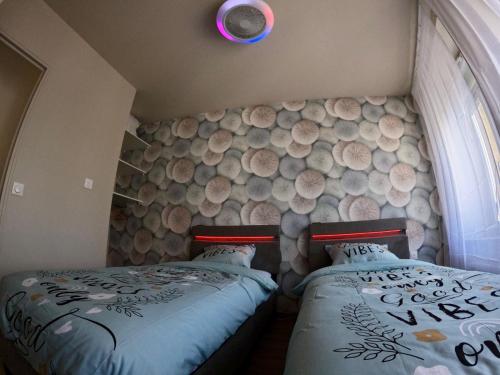 a bedroom with two beds and a wall with wine barrels at La LUNA in Le Portel
