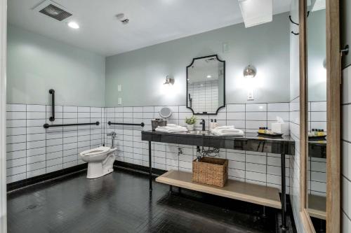 un baño con inodoro y espejo en Hangover Easy Suite 6BR by Maddox Hotel, en Nashville