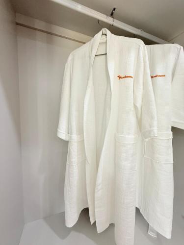 a group of white shirts hanging on a rack at Villa 4BR sát biển- Sonasea -Vân Đồn- Quảng Ninh in Thâm Câu