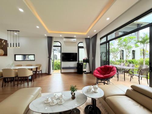 a living room with a couch and a red chair at Villa 4BR sát biển- Sonasea -Vân Đồn- Quảng Ninh in Thâm Câu