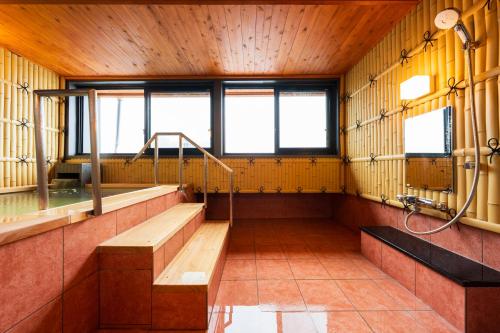 a large room with a tub and a shower at BeppuOnsen Hotel Sansenkaku in Beppu