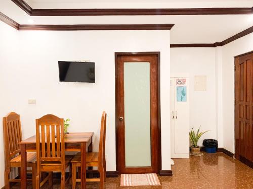 a dining room with a table and a television on a wall at PEPAYEN Homestay in General Luna