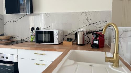 un comptoir de cuisine avec un micro-ondes et un évier dans l'établissement Le Détour - T2 de standing neuf, à Perpignan