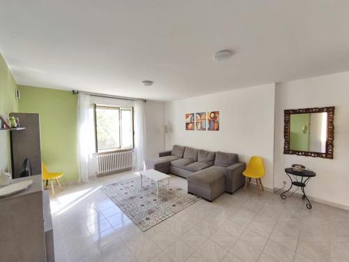 a living room with a gray couch and yellow chairs at Casa Cavallaro con Piscina estiva, giardino e parcheggio in Pescara