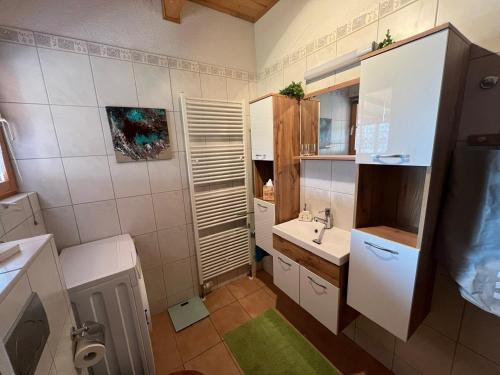 ein kleines Badezimmer mit Waschbecken und Toilette in der Unterkunft Ferienhaus Leonie, Holzhaus im Pfälzer Wald 76848 Hofstätten 