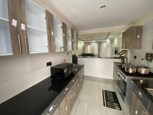 ナイロビにあるParkhust Staysの木製のキャビネットとカウンタートップを備えたキッチン