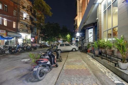 a motorcycle parked on the side of a street at night at The Batra Hotel Near Nizamuddin Railway Station in Jāmb