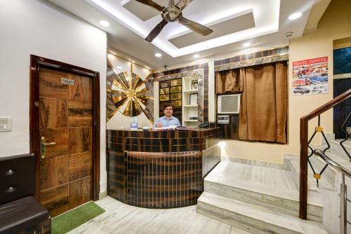 a man standing at a bar in a room at The Batra Hotel Near Nizamuddin Railway Station in Jāmb