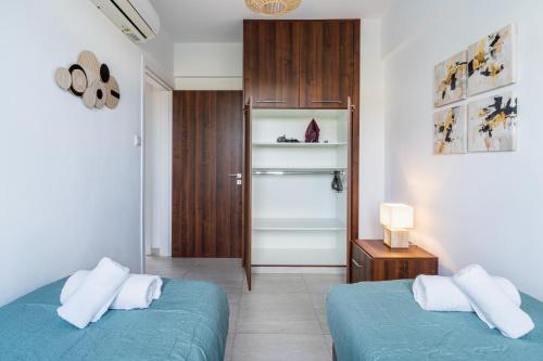a bedroom with two beds and a closet with a door at Kraken 2-Bedroom Apartment in Larnaka