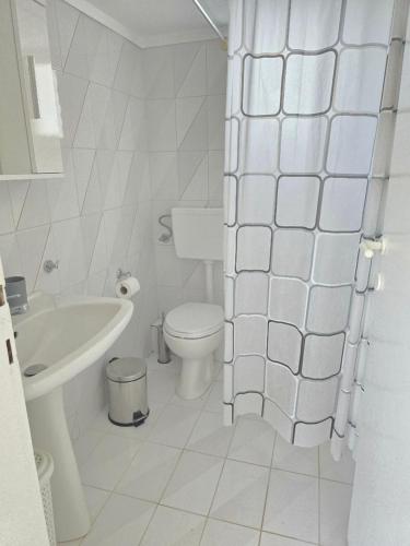 a white bathroom with a toilet and a sink at Casa Di Oliva 2 in Vergia