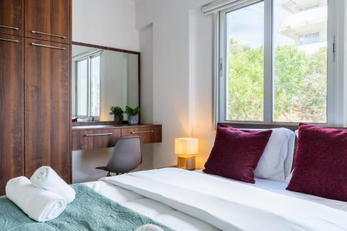 a bedroom with a large bed with purple pillows and a mirror at Kraken 2-Bedroom Apartment in Larnaka