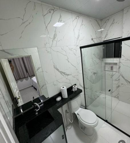 a bathroom with a toilet and a glass shower at Hotel King Palace - Hotel Irituia in Irituia