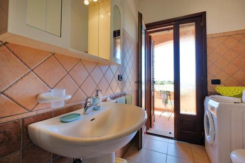 ein Badezimmer mit Waschbecken und Waschmaschine in der Unterkunft Casa "Maestrale " in Porto Pino