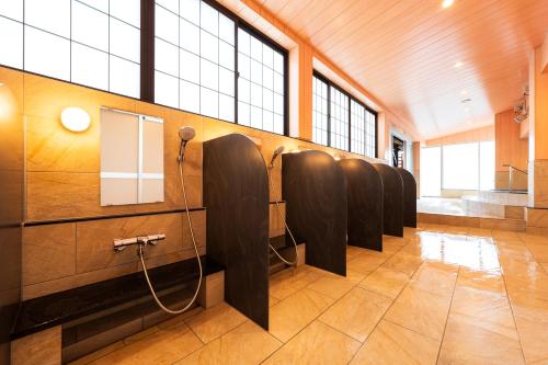 a row of urinals in a room with windows at BeppuOnsen Hotel Sansenkaku in Beppu