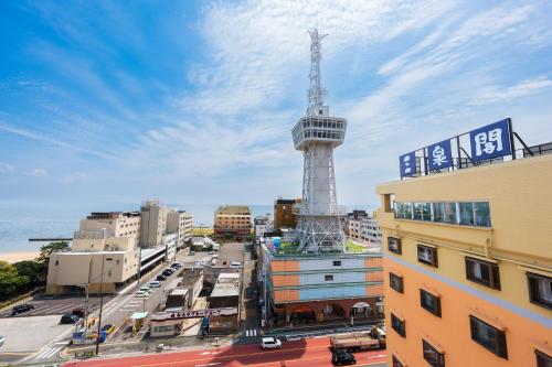 a view of a city with a tower in the background at BeppuOnsen Hotel Sansenkaku in Beppu