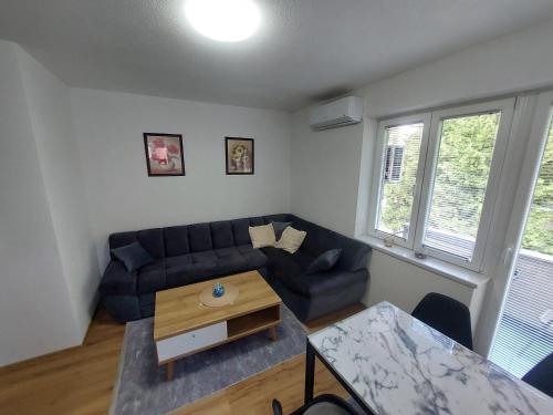 una sala de estar con un sofá y una mesa en Apartman "MEDENI", en Bihać