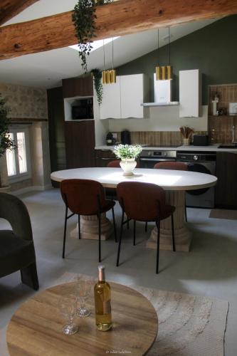une cuisine avec une table et des chaises et une cuisine avec une bouteille de vin dans l'établissement L escale Antique, à Nîmes