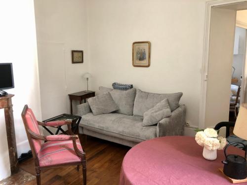 a living room with a couch and a chair at Petit appartement douillet, centre historique de Dijon in Dijon