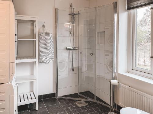 una doccia con una porta in vetro in un bagno di Boende med pool och tennisbana i familjevänligt område a Torekov