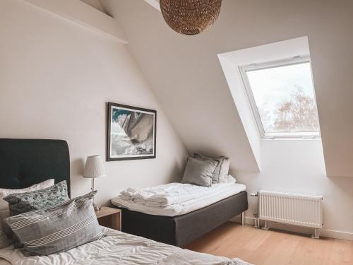 una camera mansardata con letto e finestra di Boende med pool och tennisbana i familjevänligt område a Torekov