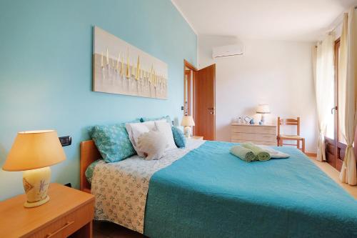 ein blaues Schlafzimmer mit einem Bett mit einer blauen Decke in der Unterkunft Casa "Maestrale " in Porto Pino