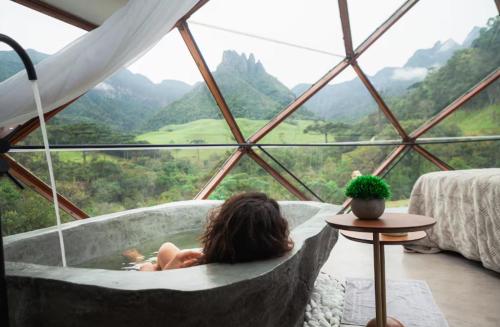 a woman in a tub in a room with a view at Morada do Guardião - Soldados Sebold in Barracão
