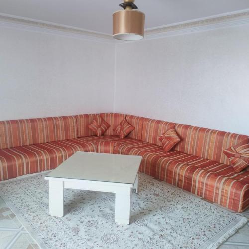 a living room with a couch and a coffee table at Chez leptis hedhoude vue mer in Lamţah