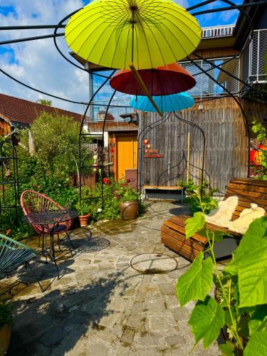 a patio with an umbrella and a table and chairs at Ferienwohnung Rheintal in Feldkirch