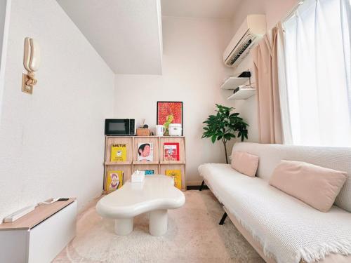 a living room with a white couch and a table at Home Story in Tokyo Kanametyo-Ikebukuro-Ginzaまで直通&東京屋語 in Tokyo