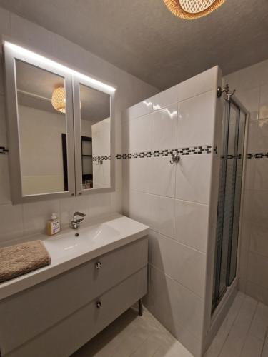a white bathroom with a sink and a shower at Chaumière historique à 5min de la plage in Veules-les-Roses