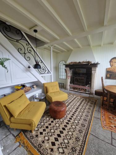 a living room with a couch and a fireplace at Chaumière historique à 5min de la plage in Veules-les-Roses