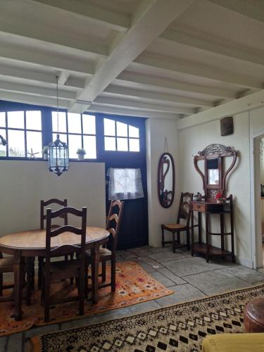 a dining room with a table and chairs at Chaumière historique à 5min de la plage in Veules-les-Roses