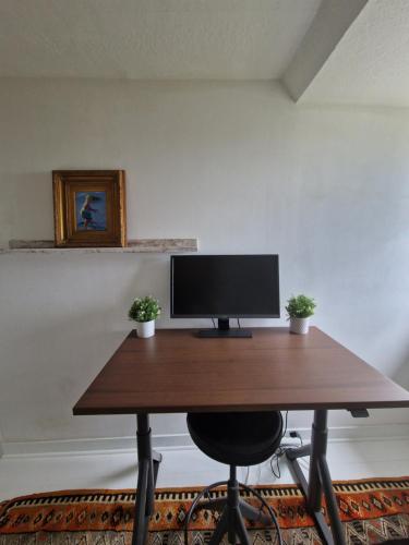 a desk with a computer monitor on top of it at Chaumière historique à 5min de la plage in Veules-les-Roses