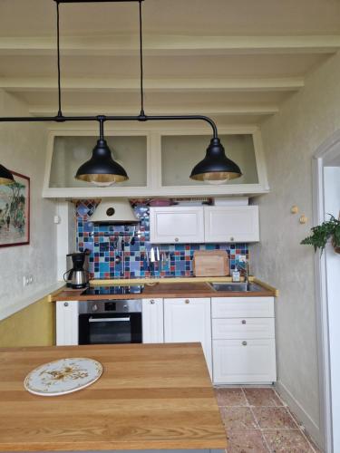 a kitchen with two lights hanging from the ceiling at Chaumière historique à 5min de la plage in Veules-les-Roses