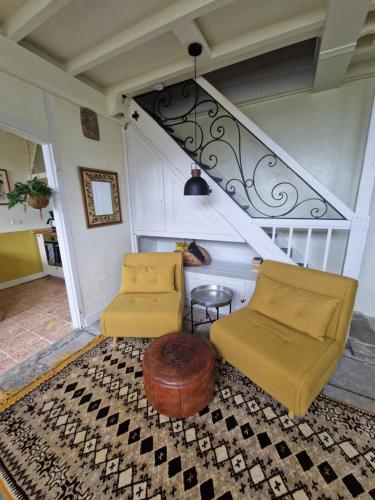 a living room with two chairs and a table at Chaumière historique à 5min de la plage in Veules-les-Roses