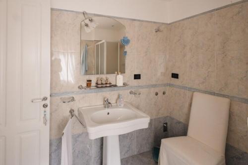 Un baño con lavabo, espejo e inodoro. en Panoramic & Exclusive Suite, en Enna
