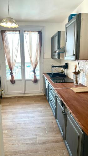 une cuisine avec un comptoir en bois dans une pièce dans l'établissement FLC bail mobilité - T3 2 Rooms - pkg - Terrace - Elevator - 7p, à Marseille