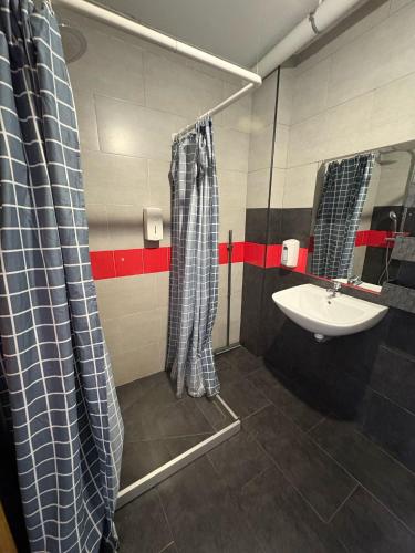 a bathroom with a shower curtain and a sink at A Casa da Herba in Redondela