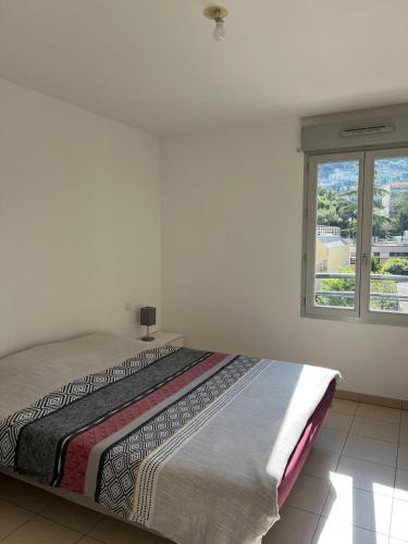 un lit dans une chambre blanche avec une fenêtre dans l'établissement Nice 2P quiet, tram, convenient, à Nice