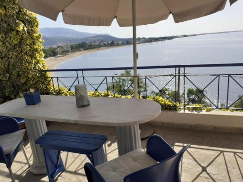 a table and chairs with a view of a beach at La Casa di Anastasia - Panorama Nea Karvali in Néa Karváli
