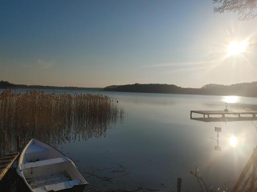 a boat sitting in the water next to a dock at Domek w Borach in Nowe