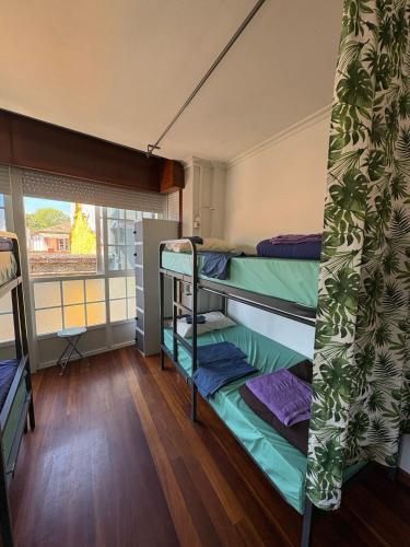 a room with three bunk beds and a window at A Casa da Herba in Redondela