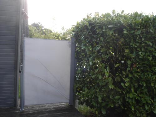 a white gate in front of a bush at Norddachhaus in Damp