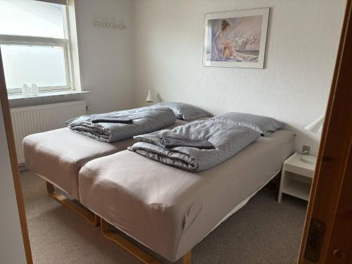 a bedroom with two beds with pillows on them at Det hyggelige hus in Hirtshals