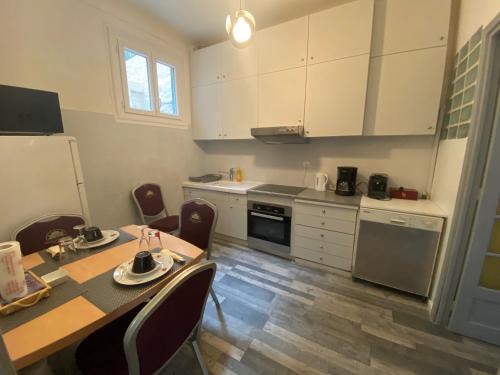 une cuisine avec une table, des chaises et un réfrigérateur dans l'établissement Charming house near Center Nice with new air conditioner, à Nice