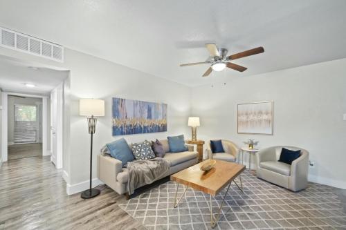 a living room with a couch and a ceiling fan at Spacious and Stylish Apartment right by AT&T Stadium! in Arlington