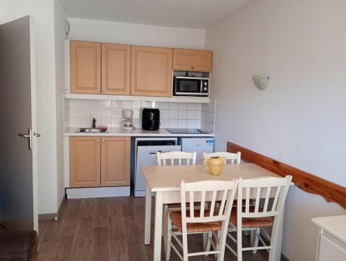 Una cocina con una mesa y sillas en una cocina. en appartement valmeinier 1800, en Valmeinier