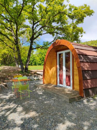 a small wooden cabin with a window and a chair at Camping du Moulin de Thoard in Thoard