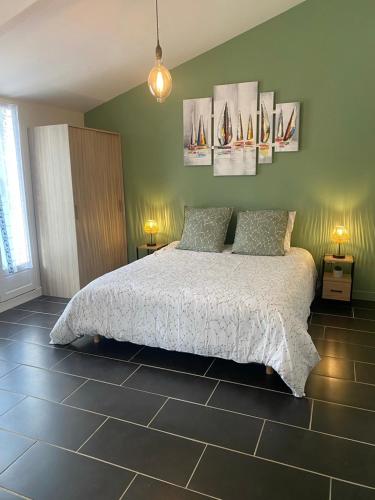 a bedroom with a bed and some pictures on the wall at Gîte des Petites Fadettes "MELUSINE" in Lannepax